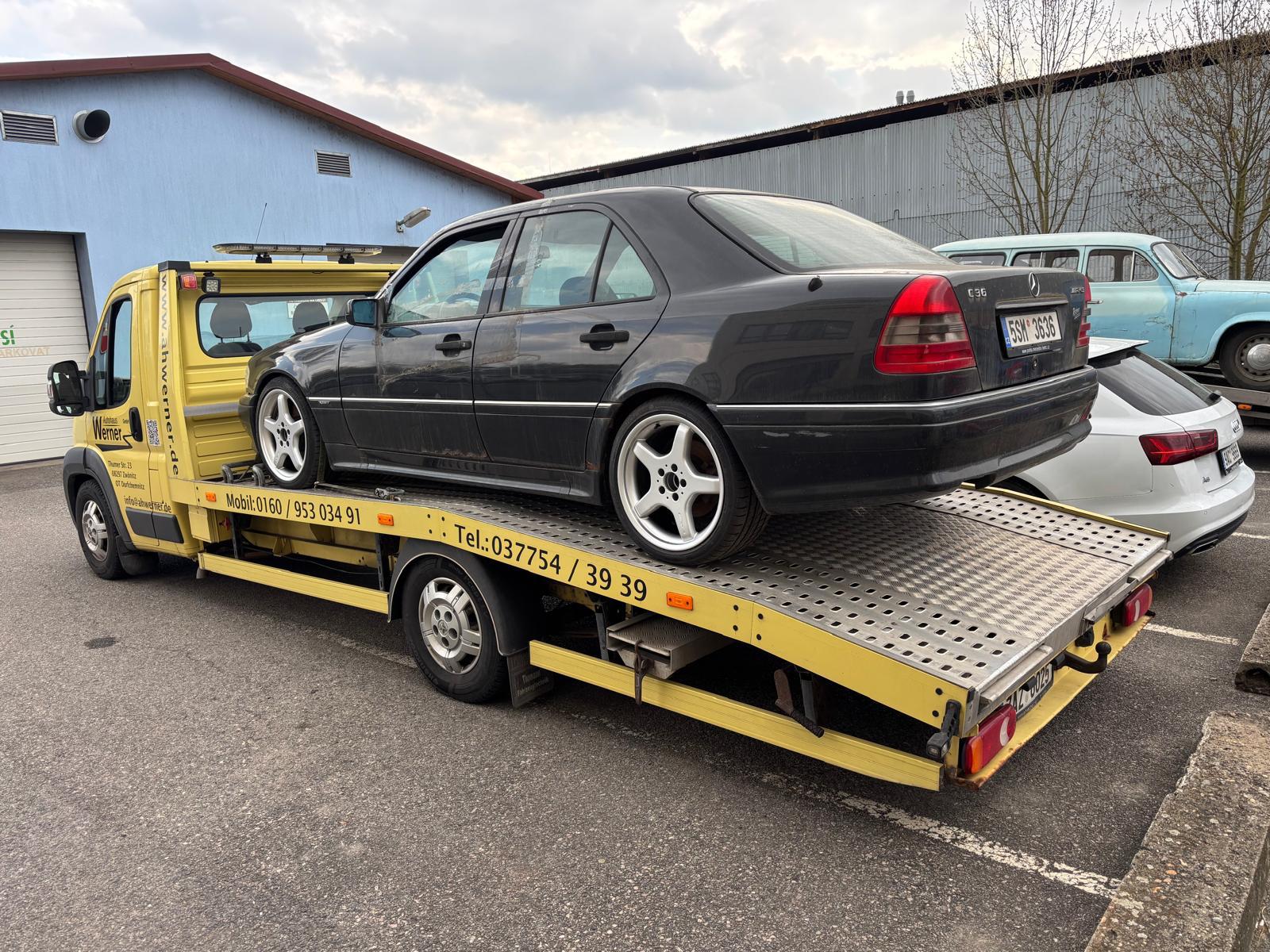 Žlutá odtahovka s Mercedesem